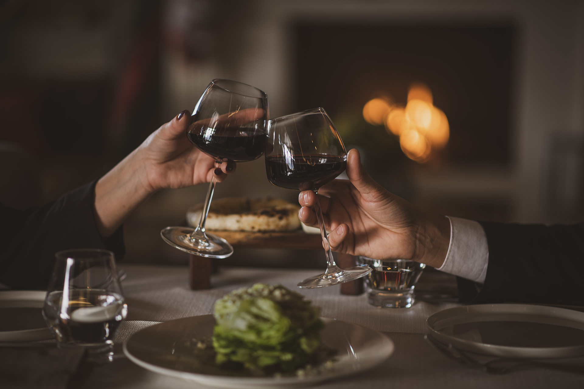 midsection-couple-holding-wine-glass-table